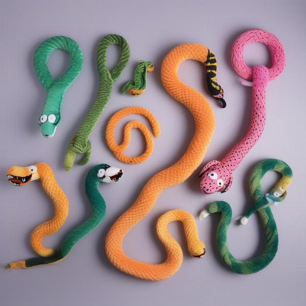 Different types of squeaky snake dog toys arranged on a white background.