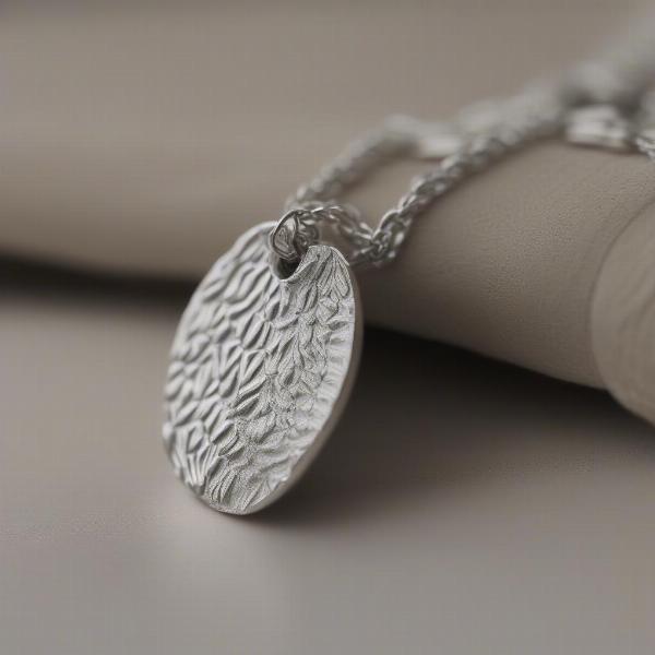 Close-up of a silver dog nose print necklace, showcasing the intricate details of the nose print.