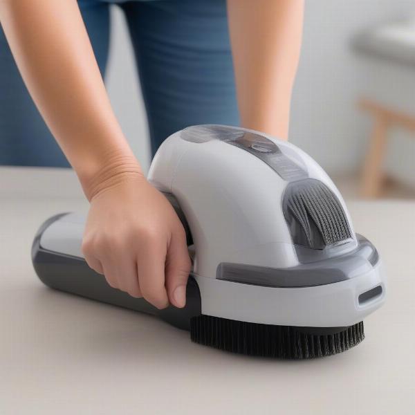 Close-up of cleaning the brush head of a dog hair vacuum groomer.