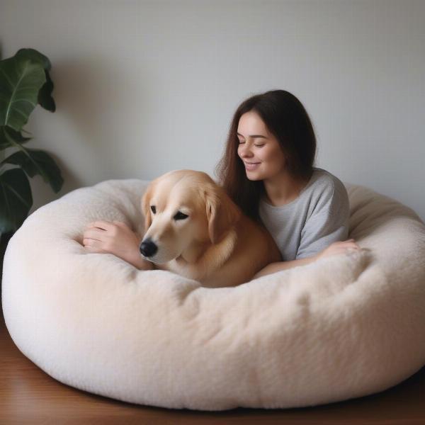 Person and dog lying together on a large dog bed